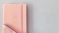 2021 New year pink slim diary and pen with gray background. details.
