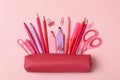 Pink pencil case different supplies on pink background Royalty Free Stock Photo