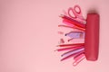 Pink pencil case different supplies on pink background Royalty Free Stock Photo