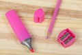 Pink pencil, highlighter and pencil sharpener on wooden desk Royalty Free Stock Photo