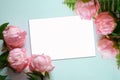 Pink Peonies artificial flowers on blue background with  blank white note paper Royalty Free Stock Photo