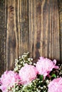 Pink Peonies and Babys Breath Flowers over a Natural Rustic Wood Background Royalty Free Stock Photo