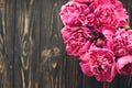 pink peonies bouquet on rustic dark wooden background, top view, space for text. floral greeting card mock-up, flat lay. happy mo