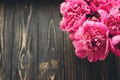 pink peonies bouquet on rustic dark wooden background, top view, space for text. floral greeting card mock-up, flat lay. happy mo