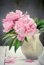 Pink peonies in retro vase on wooden table, vintage colors, tone