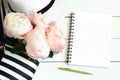 Pink peonies, striped bag, summer hat and empty notebook for message Royalty Free Stock Photo