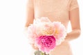 Pink peonies in woman`s hands. Elegant bunch of beautiful flowers, soft white background, shallow dof, copy space.