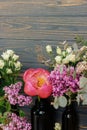 Pink peony, lilac, eucalyptus, roses flowers on dark rustic wood. Spring stylish bouquet still life Royalty Free Stock Photo