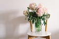 Pink Peonys bouquet on a white chair in the living room.