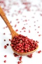 Pink pepper balls in a wooden spoon Royalty Free Stock Photo
