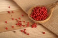 Pink pepper balls in a wooden spoon Royalty Free Stock Photo