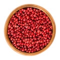 Pink pepper in wooden bowl over white Royalty Free Stock Photo