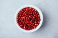 Pink peppercorn in white bowl on gray stone concrete background Royalty Free Stock Photo