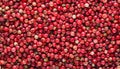 Pink peppercorns background, top view.