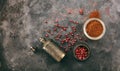 Pink peppercorns and powder and a bronze pepper mill on metal rusty background, top view, copy space Royalty Free Stock Photo