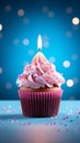 Pink perfection Birthday cupcake with burning candle on blue background Royalty Free Stock Photo