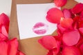 Pink petals of rose with letter in an envelope with kiss lipstick isolated on the white background