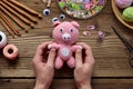 Pink pig. Crochet toy for child. On table threads, needles, hook, cotton yarn. Handmade crafts. DIY concept. Small business.