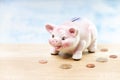 Pink pig piggy bank next to coins on a table Royalty Free Stock Photo