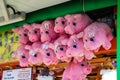 Pink pig stuffed animals hanging from the ceiling at a carnival game at the Santa Monica Pier