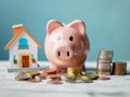 Pink piggy bank, coins and house, financial investment and money saving concept. Royalty Free Stock Photo