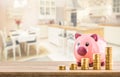 Pink piggy bank coins and modern kitchen interior in the background. Bank construction or insurance concept Royalty Free Stock Photo