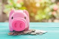 Pink piggy bank over coins stack, saving money Royalty Free Stock Photo