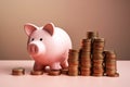 Pink piggy bank on the right side, To the left of the piggy bank are stacks of coins in ascending order Royalty Free Stock Photo