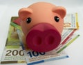 Pink piggy bank with swiss money and currency of switzerland. Swiss francs. Money in Switzerland Royalty Free Stock Photo