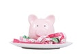 Pink piggy bank with tape measures on a plate Royalty Free Stock Photo