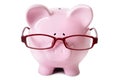 Pink piggybank wearing glasses isolated on white background, front view, savings wisdom Royalty Free Stock Photo