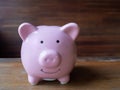 Pink piggy bank with wooden background for coppy space