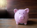 Pink piggy bank with wooden background for coppy space