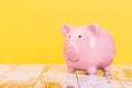 pink piggy bank on a yellow background, space for text. Finance, saving money, crisis. Business