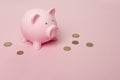 Pink piggybank with euro coins seen from a high anlge view on a pink background as concept for financial issues with space for Royalty Free Stock Photo