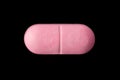 Pink pill isolated on black Royalty Free Stock Photo