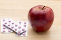 Pink pills blister pack and fresh red apple Royalty Free Stock Photo