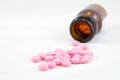 Pink pills and bottle isolated on white Royalty Free Stock Photo