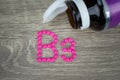 Pink pills forming shape to B3 alphabet on wood background Royalty Free Stock Photo