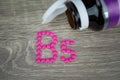 Pink pills forming shape to B5 alphabet on wood background Royalty Free Stock Photo