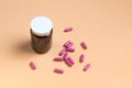 Pink pills in the glass bottle on a orange background Royalty Free Stock Photo