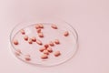 Pink pills on glass plate on pink background Royalty Free Stock Photo