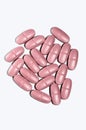 Pink pills pile on white
