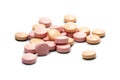 Pink pills on a small heap isolated with shadows on a white back