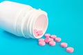 Pink Pills Spill Out From Bottle On Blue Background Royalty Free Stock Photo