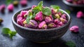 Pink pistachios in bowl with mint on dark surface Royalty Free Stock Photo