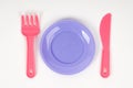 Pink plastic baby pink fork ,knife and plate on a white background isolated Royalty Free Stock Photo
