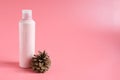 Pink plastic bottle for liquid soap or bodylotion ,cosmetique with dry nature brown pine fruit on pink background with space for