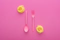 Pink plastic fork and spoon upside down near vermicelli pasta on pink background. Royalty Free Stock Photo