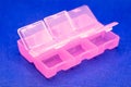 Pink plastic organizer with cells on a blue